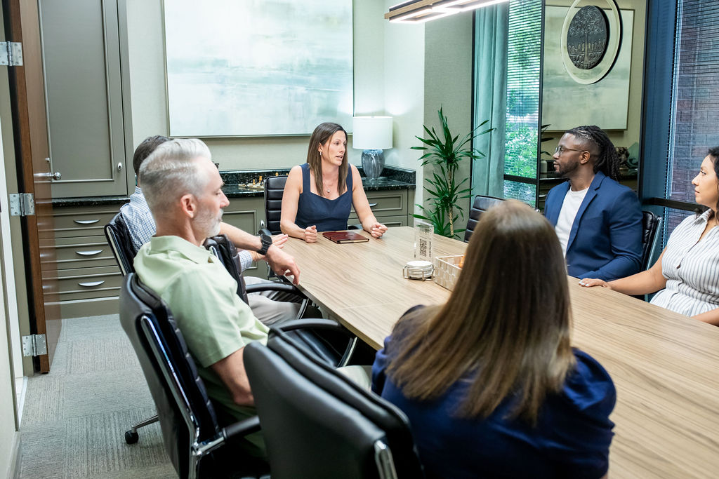 WFA Volare advisors in conversation with clients around the conference table